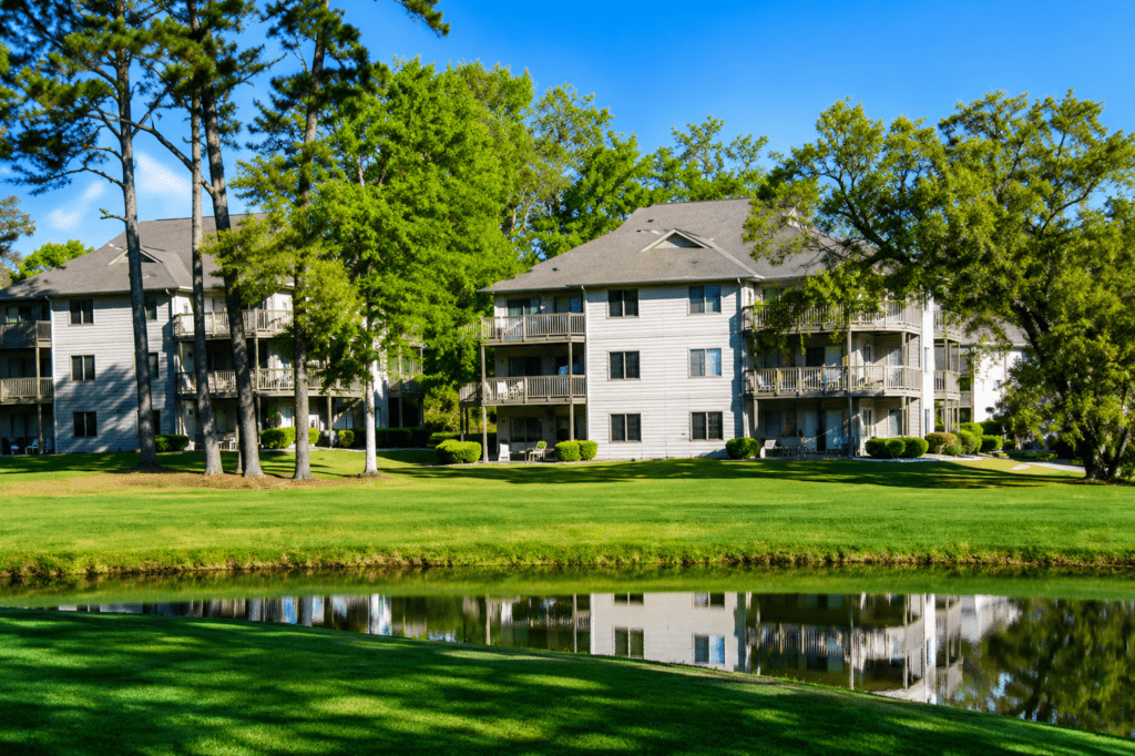 Apartment buildings by pond with tree reflections