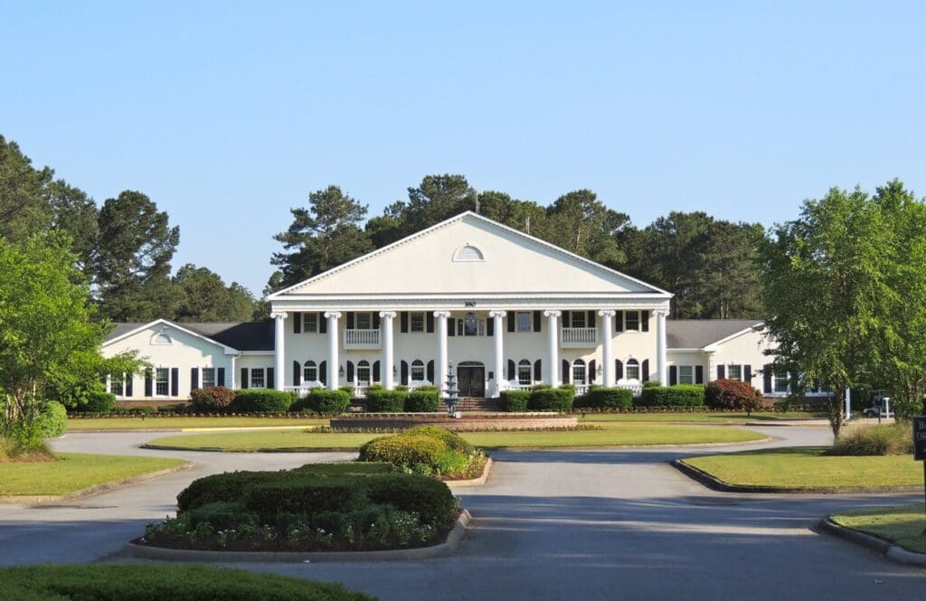 Grand white neoclassical mansion on landscaped grounds