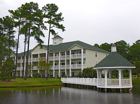 White gazebo by a lakefront building