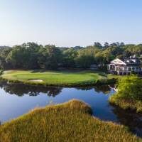 Golf course green by water and clubhouse