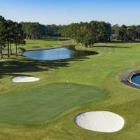 Golf course green with bunkers and water